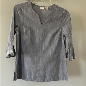 Women’s washed denim v-neck top with 3/4 length eyelet detail on sleeves.